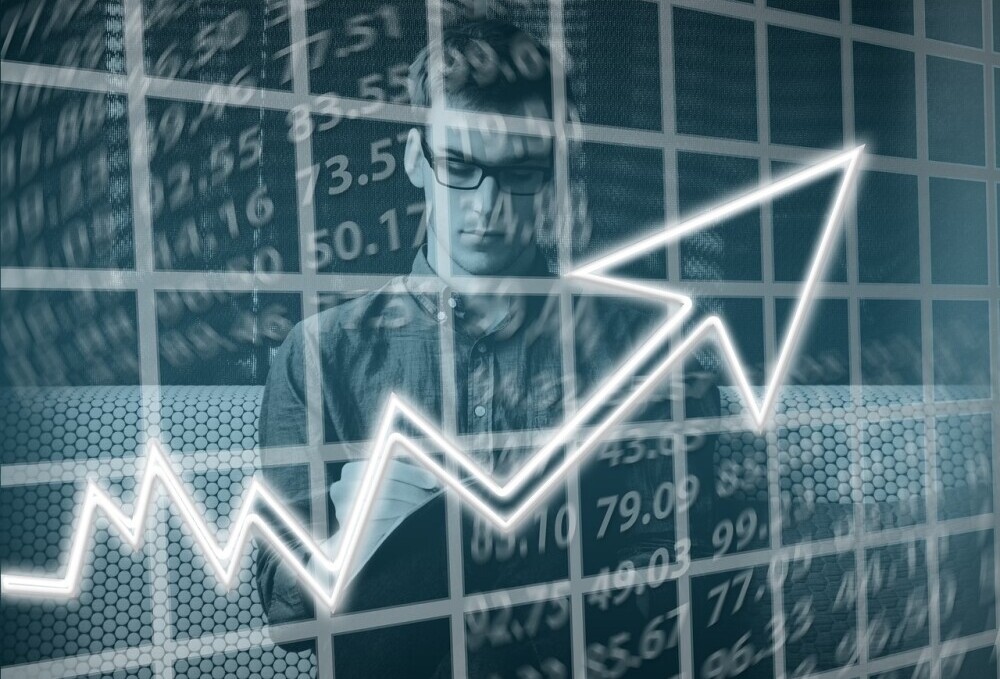 graphic showing online growth with arrow pointing upward and image of man on a laptop